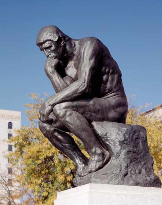 Large bronze sculpture of Rodin's iconic 'The Thinker,' depicting a seated male figure deep in thought with his chin resting on one hand. The intricate details of the muscular physique and thoughtful expression are enhanced by the patina of the bronze, capturing the essence of intellectual contemplation and strength.