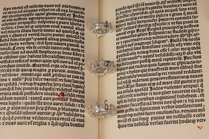 Three sterling 925 silver rings engraved with 'sub specie aeternitatis,' placed on an open book with intricate blackletter font in the background.